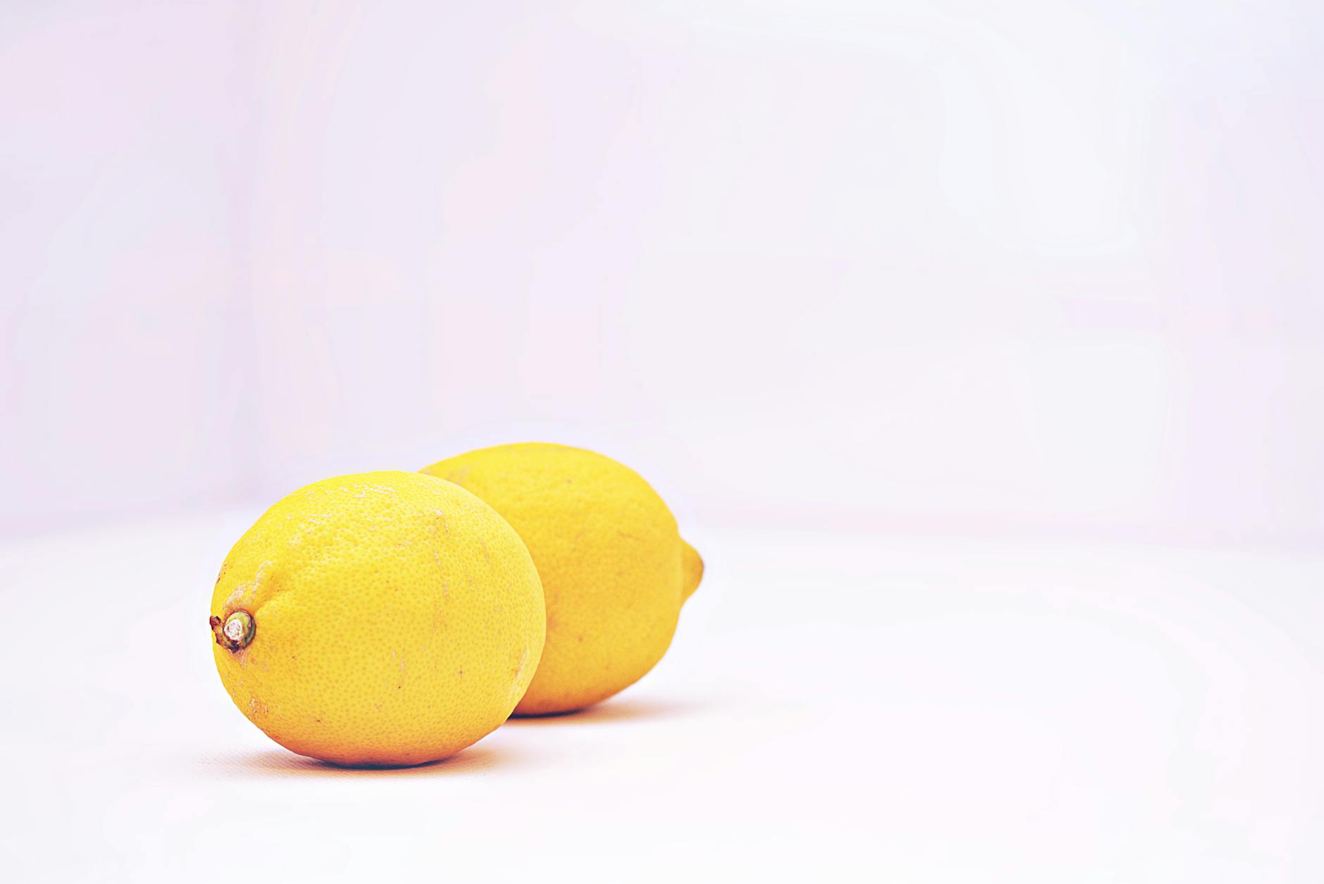 Two vibrant lemons on a minimalist white background