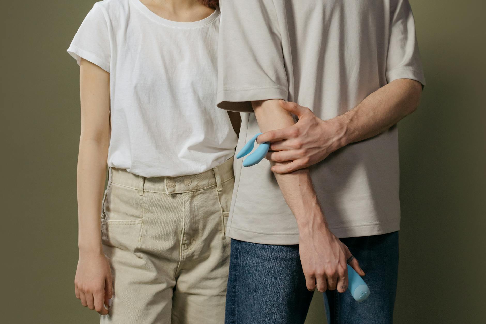 A young couple standing together indoors, comfortable and connected