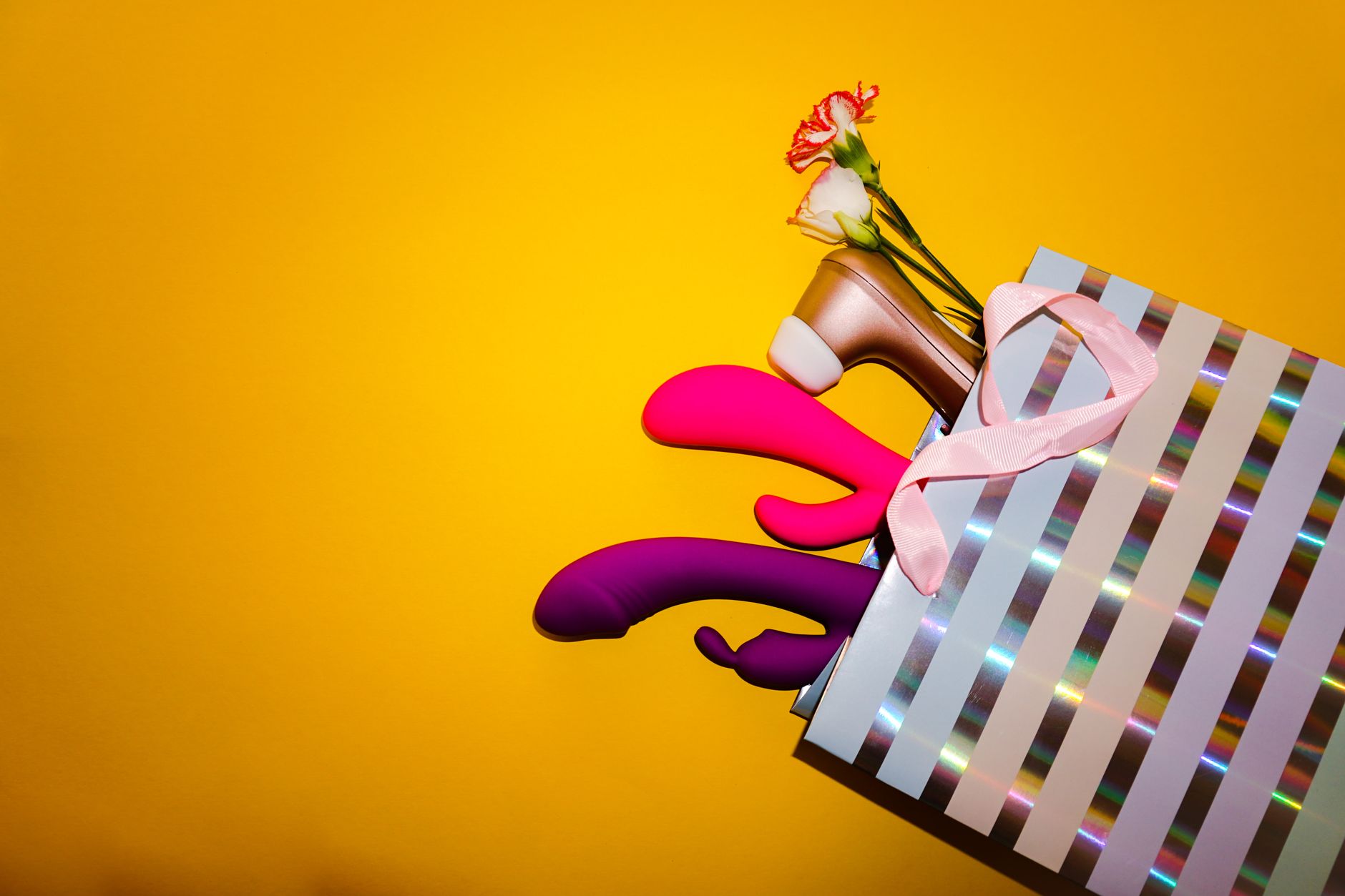 A vibrant collection of various sex toys on a black tray, featuring diverse shapes and colors.
